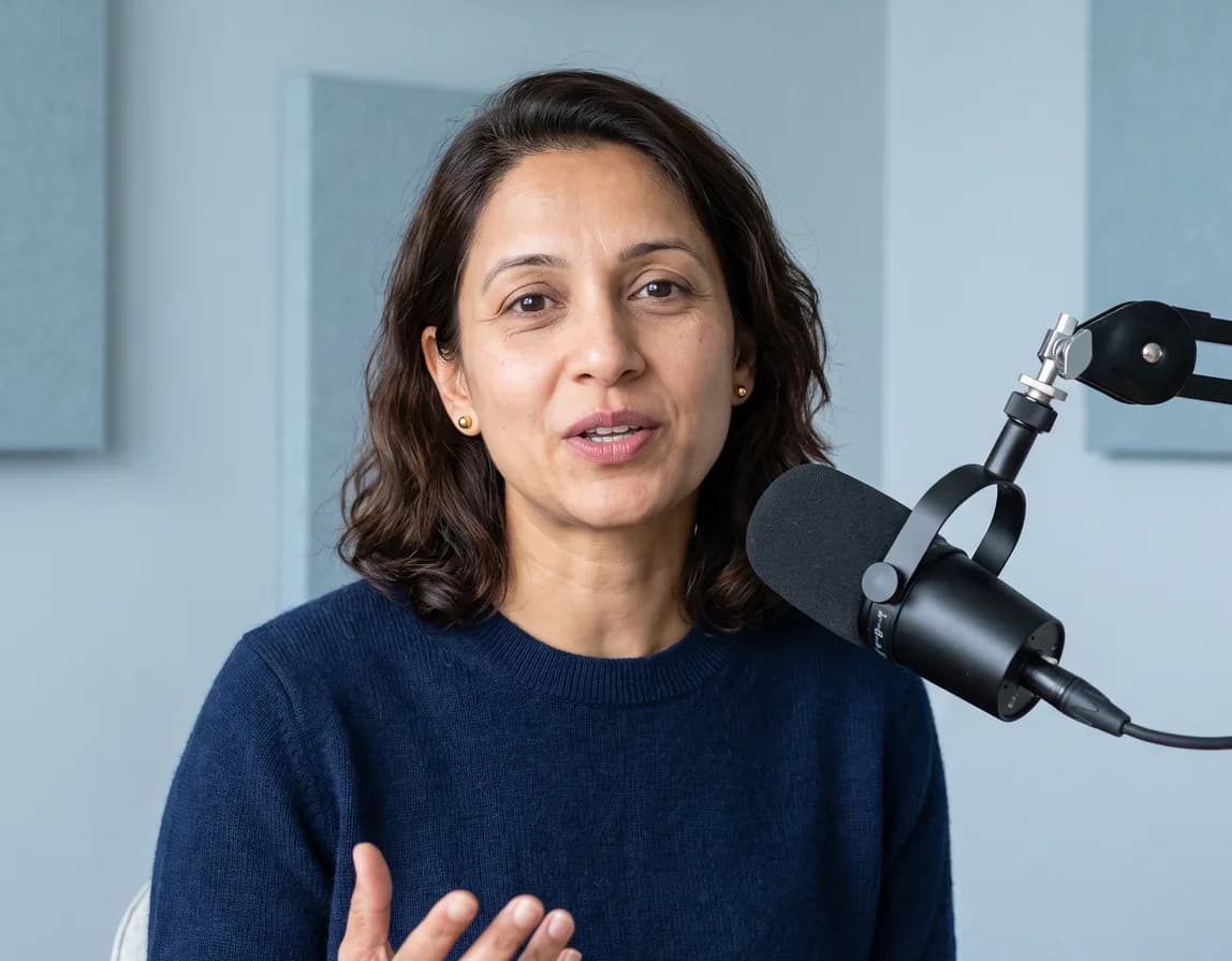 A woman speaking into a close microphone in a treated studio