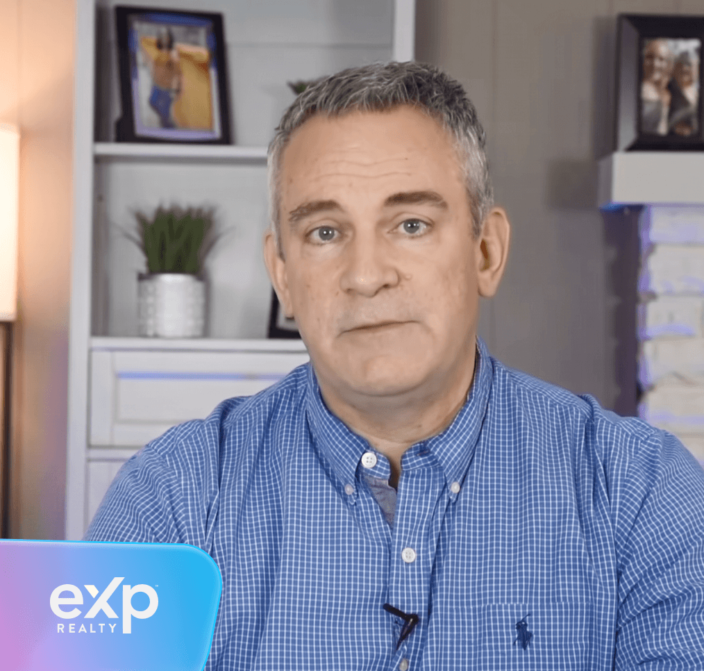 A man in a blue checkered shirt looks forward, with an EXP Realty logo in the lower left.