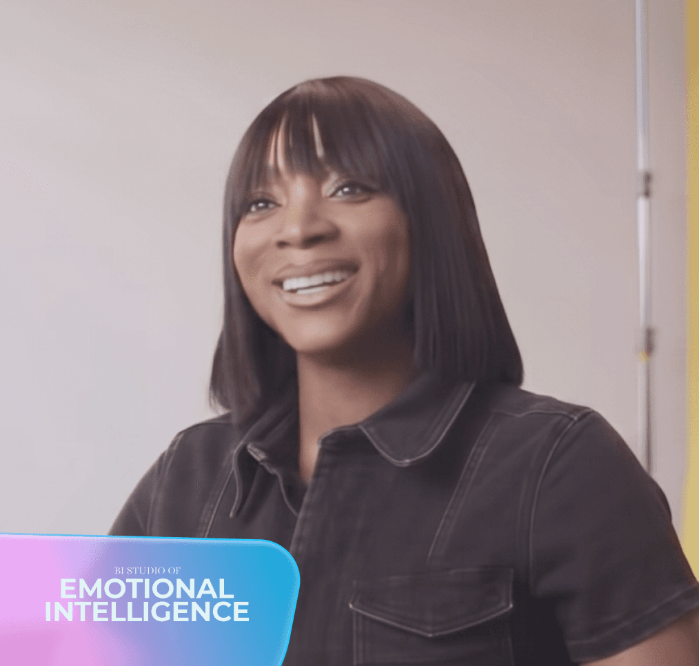 A smiling Black woman with dark hair and bangs wears a dark shirt; a "BI STUDIO OF EMOTIONAL INTELLIGENCE" graphic is in the bottom left.